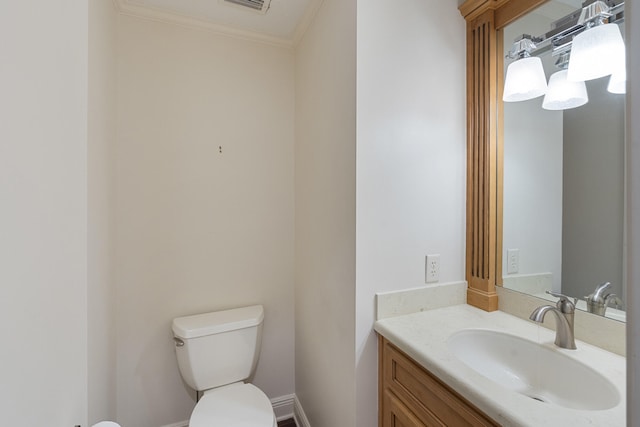 half bath with toilet, vanity, baseboards, and ornamental molding