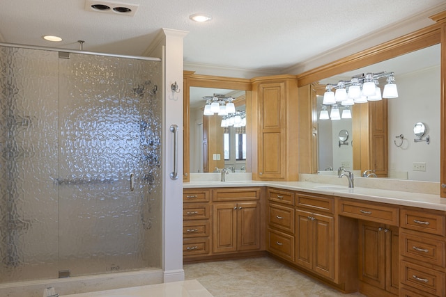 full bathroom with a stall shower, crown molding, and a sink