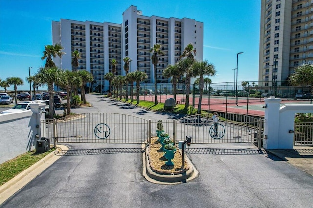 view of road featuring a gate, curbs, and a gated entry