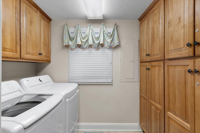 laundry room featuring cabinet space, a textured ceiling, separate washer and dryer, electric panel, and baseboards