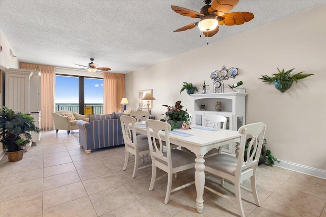 dining room with a ceiling fan, a textured ceiling, and light tile patterned floors