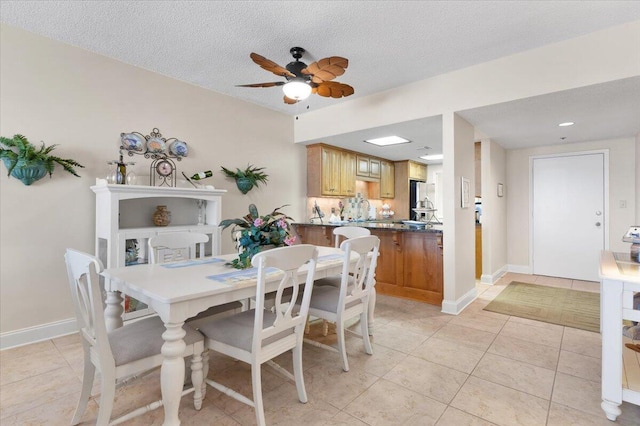 dining room with light tile patterned floors, baseboards, and a textured ceiling