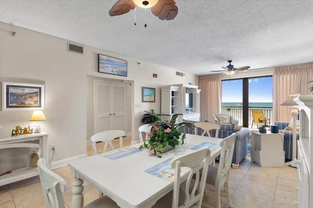 dining space with ceiling fan, a fireplace, and visible vents