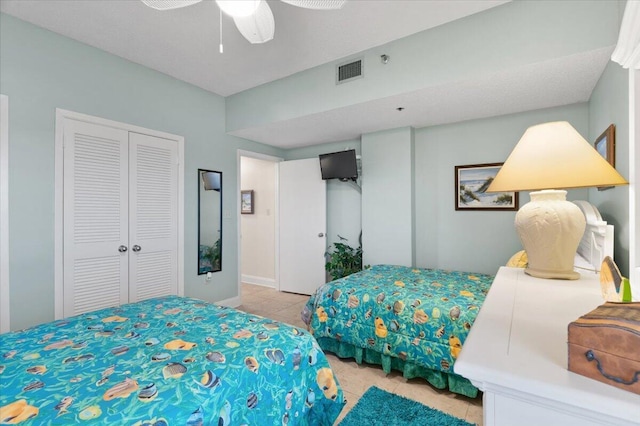 tiled bedroom featuring a ceiling fan, a closet, and visible vents