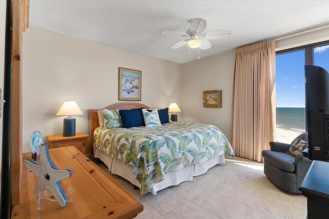 bedroom with a textured ceiling, ceiling fan, and light tile patterned floors