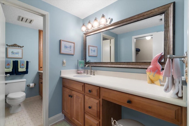 bathroom featuring a textured ceiling, toilet, tile patterned flooring, and vanity