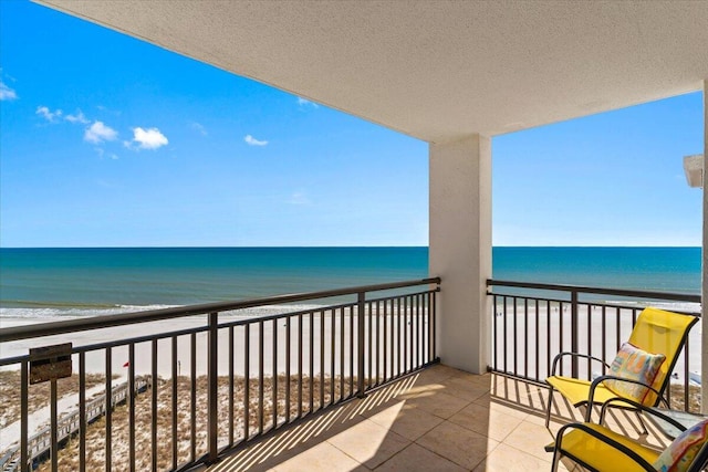 balcony featuring a water view and a view of the beach