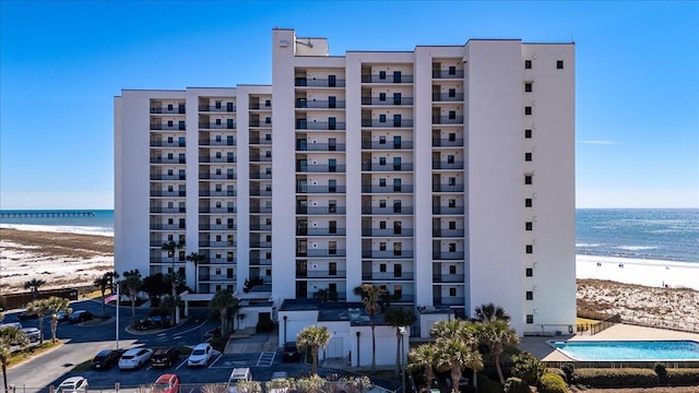 view of building exterior featuring a water view and a view of the beach