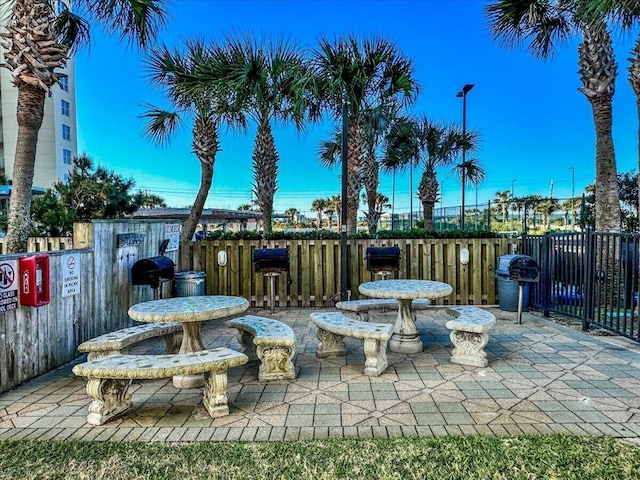 view of patio featuring a grill and fence