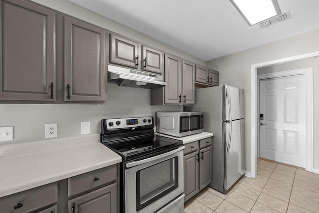 kitchen featuring stainless steel appliances, light countertops, visible vents, gray cabinetry, and under cabinet range hood