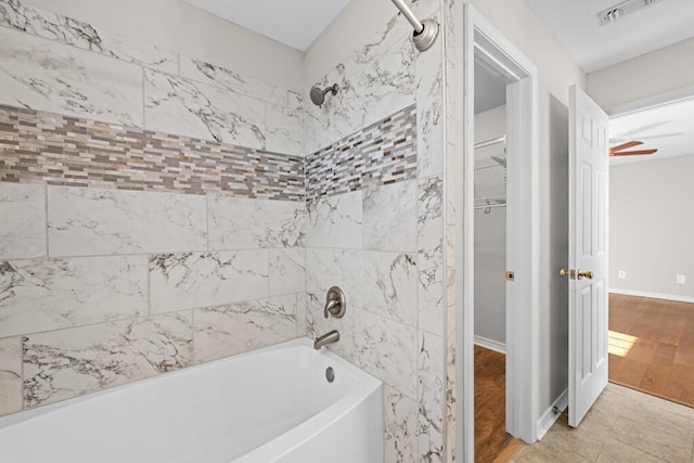 bathroom with shower / bath combination, wood finished floors, visible vents, and baseboards