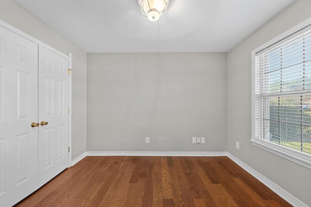 unfurnished bedroom featuring baseboards and wood finished floors