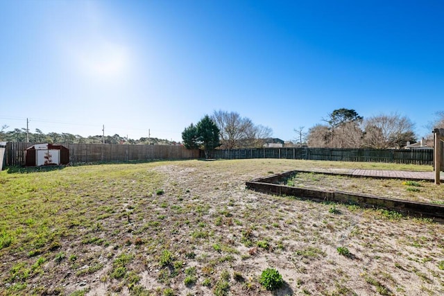 view of yard featuring a storage unit, an outdoor structure, and a fenced backyard