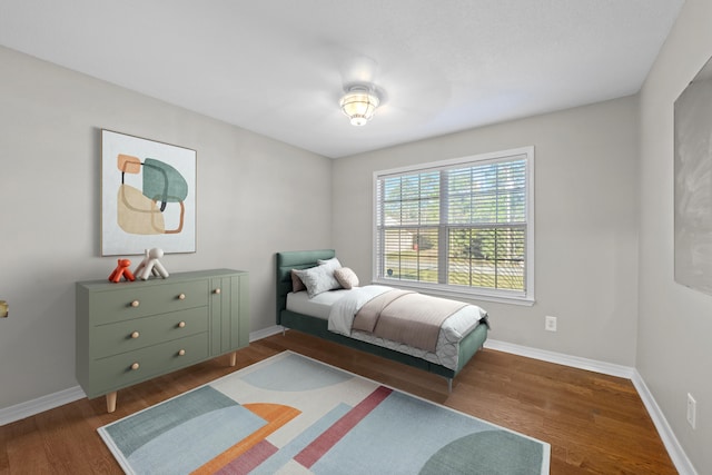 bedroom with baseboards and wood finished floors