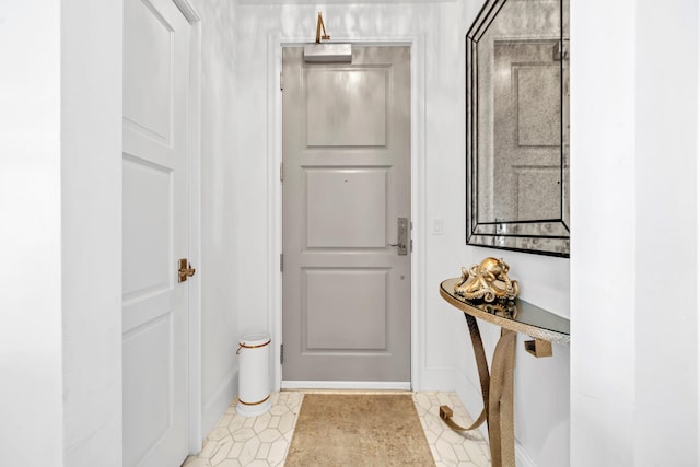 doorway to outside with light tile patterned floors and baseboards