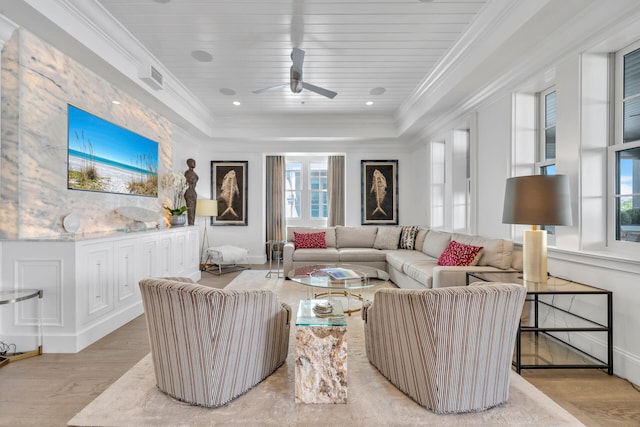 living area featuring ceiling fan, recessed lighting, light wood-style floors, a raised ceiling, and crown molding