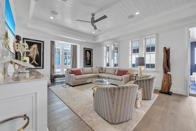 living area with wooden ceiling, ornamental molding, and a raised ceiling