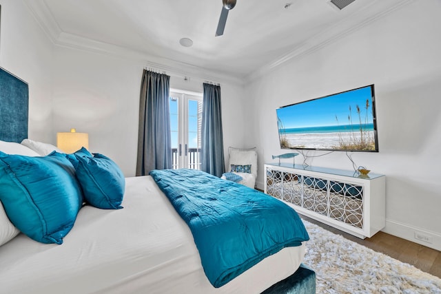 bedroom featuring visible vents, ornamental molding, a ceiling fan, wood finished floors, and baseboards