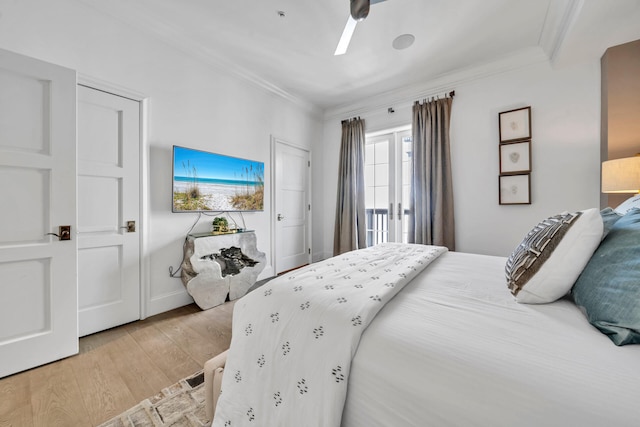 bedroom featuring ornamental molding, light wood-type flooring, and a ceiling fan