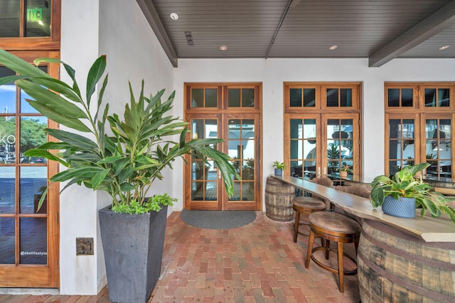 property entrance featuring stucco siding, outdoor dry bar, and french doors