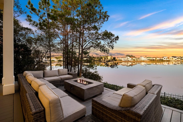 exterior space featuring an outdoor living space with a fire pit and a water view