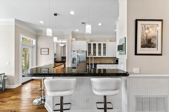 kitchen featuring crown molding, visible vents, a sink, and stainless steel fridge with ice dispenser