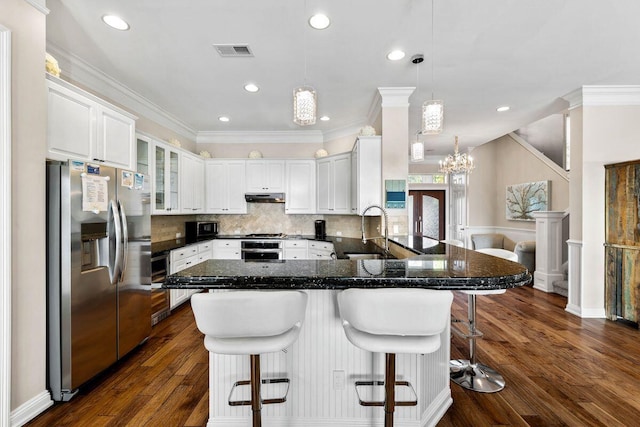 kitchen with stainless steel appliances, visible vents, a sink, a peninsula, and under cabinet range hood