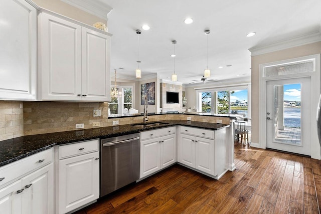 kitchen featuring tasteful backsplash, ornamental molding, a sink, dishwasher, and a peninsula