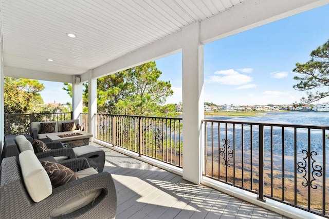 exterior space with a water view, a sunroom, and an outdoor fire pit