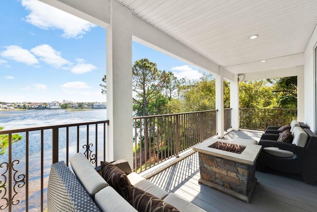 exterior space with a water view and an outdoor living space with a fire pit