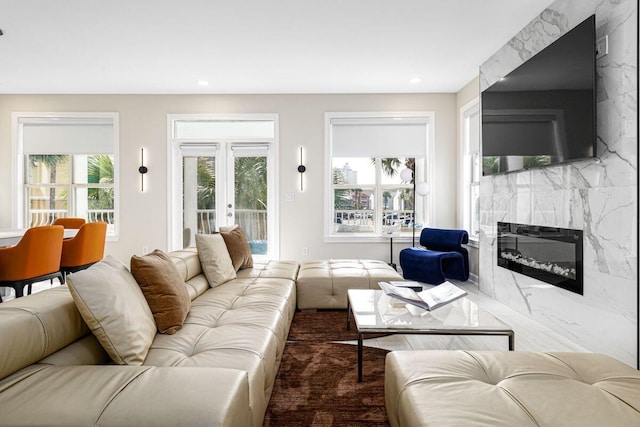 living room with french doors, a fireplace, and recessed lighting