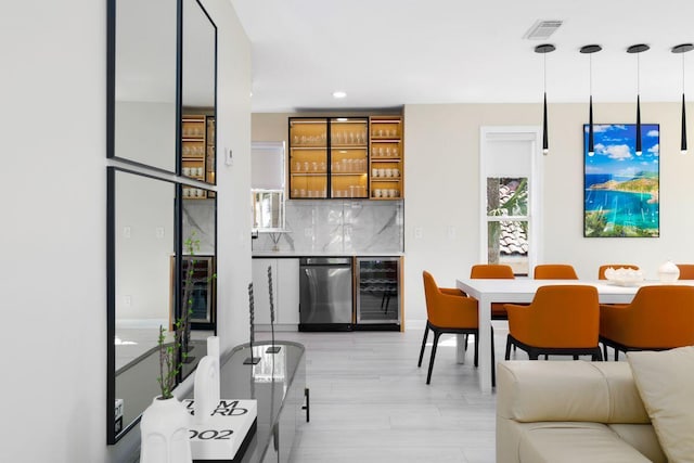 interior space with visible vents, dishwasher, light wood-style flooring, wine cooler, and backsplash