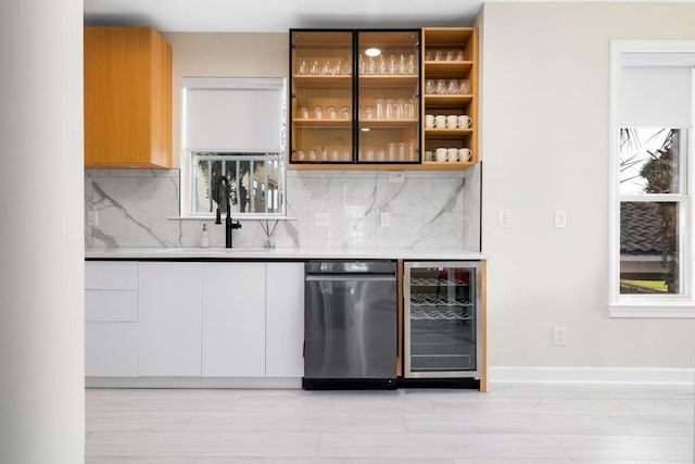 bar with a healthy amount of sunlight, beverage cooler, a dry bar, and decorative backsplash