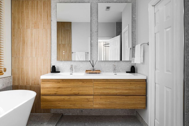 bathroom with a soaking tub, visible vents, a sink, and double vanity