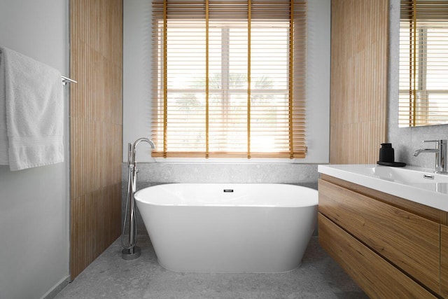 full bath featuring a freestanding tub and vanity