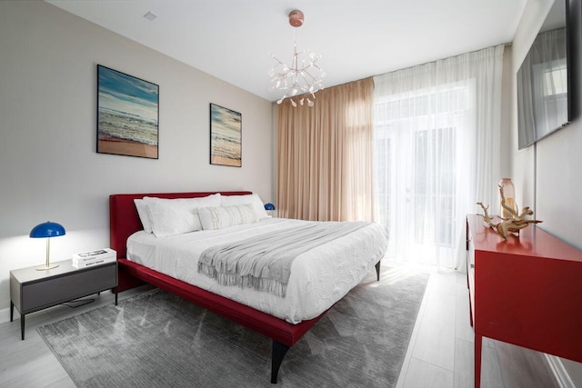 bedroom with wood finished floors and a notable chandelier