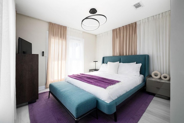 bedroom with visible vents and wood finished floors