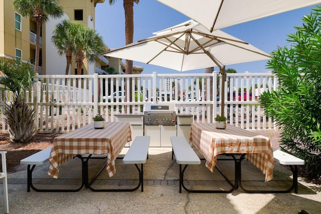 view of patio featuring fence, an outdoor kitchen, and area for grilling