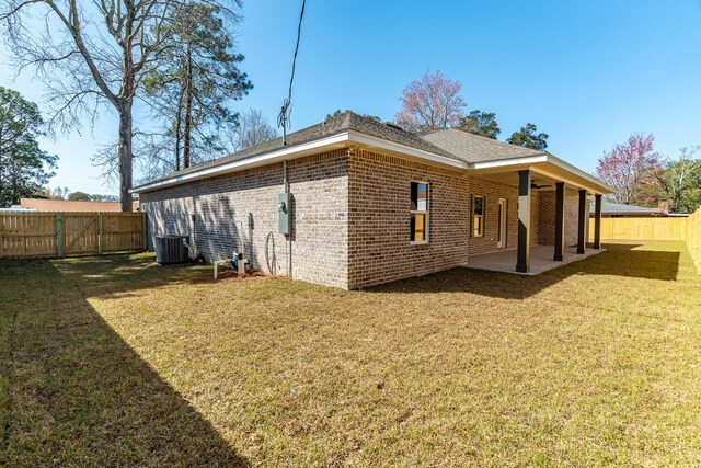 view of home's exterior with a lawn, a patio, a fenced backyard, a gate, and brick siding