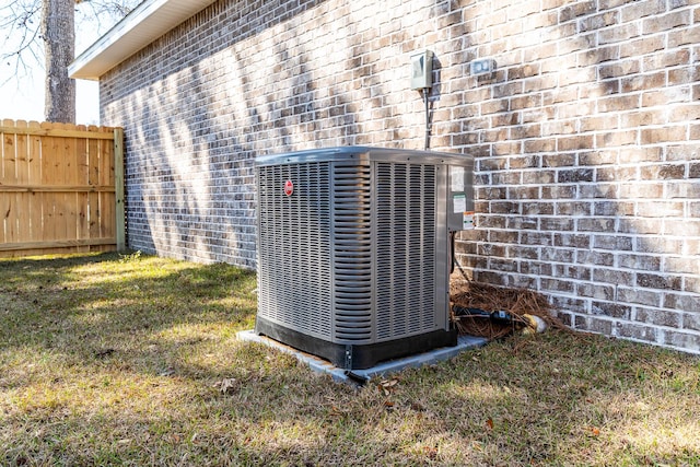 details with brick siding, cooling unit, and fence