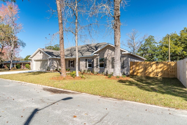 view of front of property with an attached garage, a front yard, fence, and brick siding