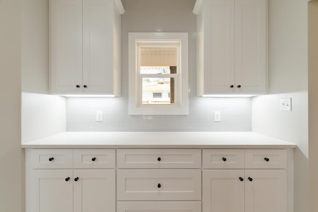 kitchen with light countertops, white cabinetry, and decorative backsplash