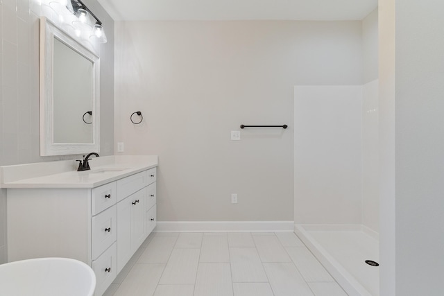 bathroom with a freestanding tub, tile patterned flooring, vanity, baseboards, and walk in shower