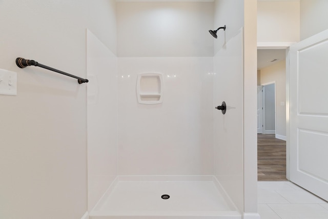 full bathroom featuring tile patterned flooring and a shower