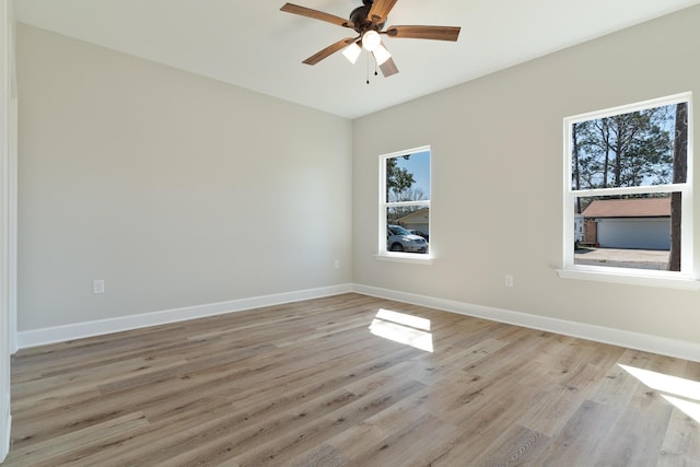 unfurnished room with light wood-style floors, ceiling fan, and baseboards