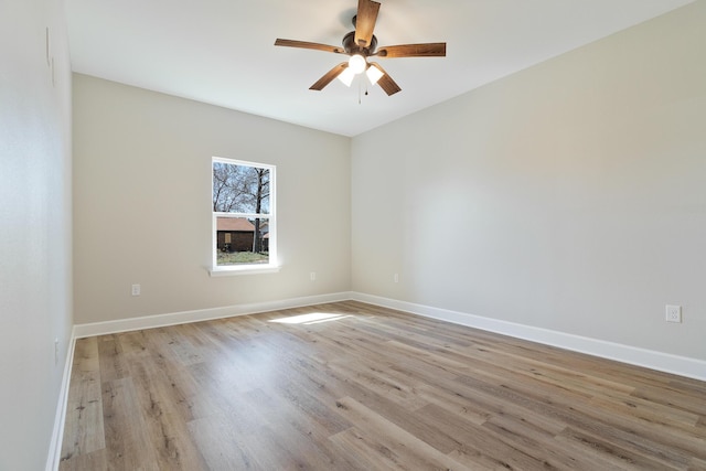 empty room with a ceiling fan, light wood-type flooring, and baseboards