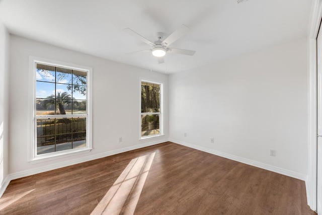 empty room with ceiling fan, baseboards, and dark wood-style flooring