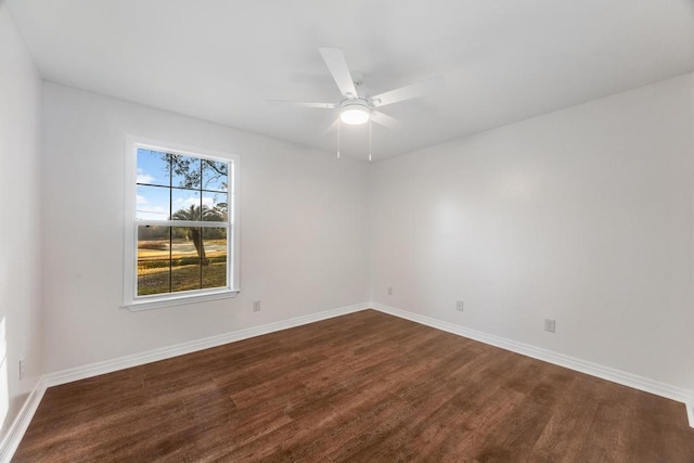 empty room featuring a ceiling fan, dark wood-style floors, and baseboards