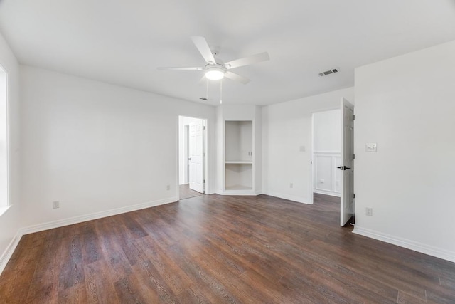 interior space featuring visible vents, baseboards, dark wood-style floors, and a ceiling fan