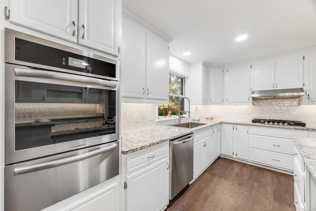 kitchen featuring a sink, stainless steel appliances, white cabinets, under cabinet range hood, and a warming drawer